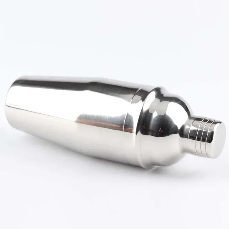 Stainless steel cocktail shaker lying at an angle on a white background