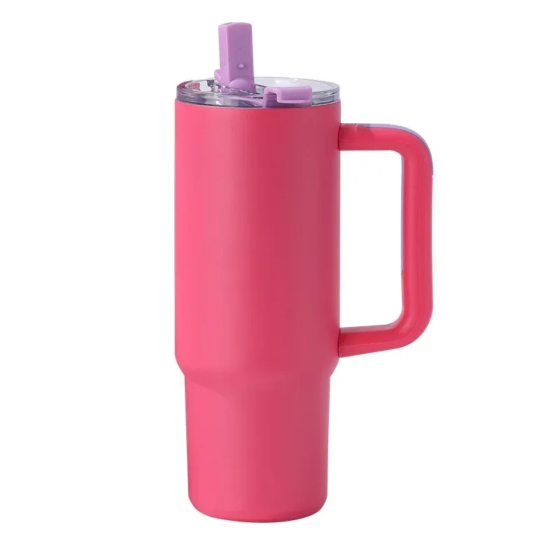 Rose red insulated tumbler with molded side handle, clear lid with lilac straw and purple flip tab, three-quarter view on white background