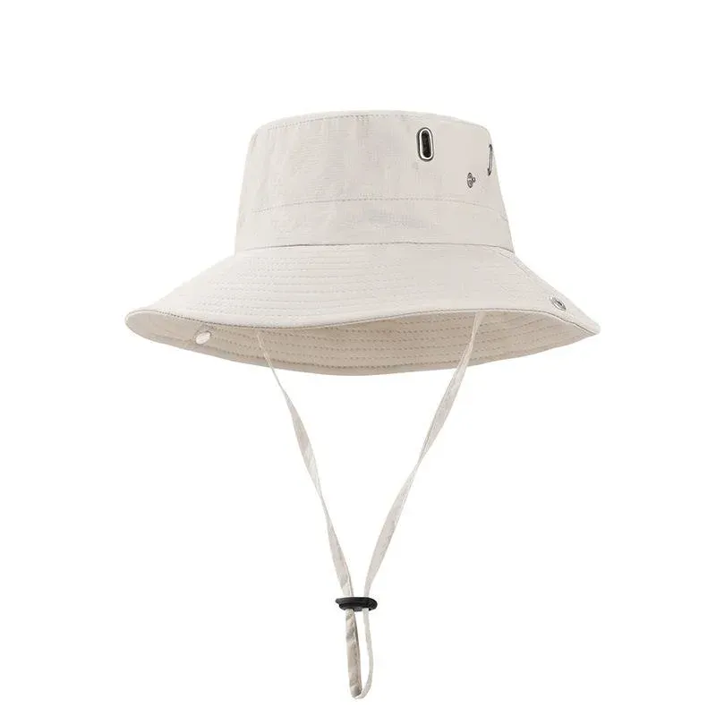 Beige wide-brim bucket hat with metal eyelets and a chin cord with cinch toggle, front view