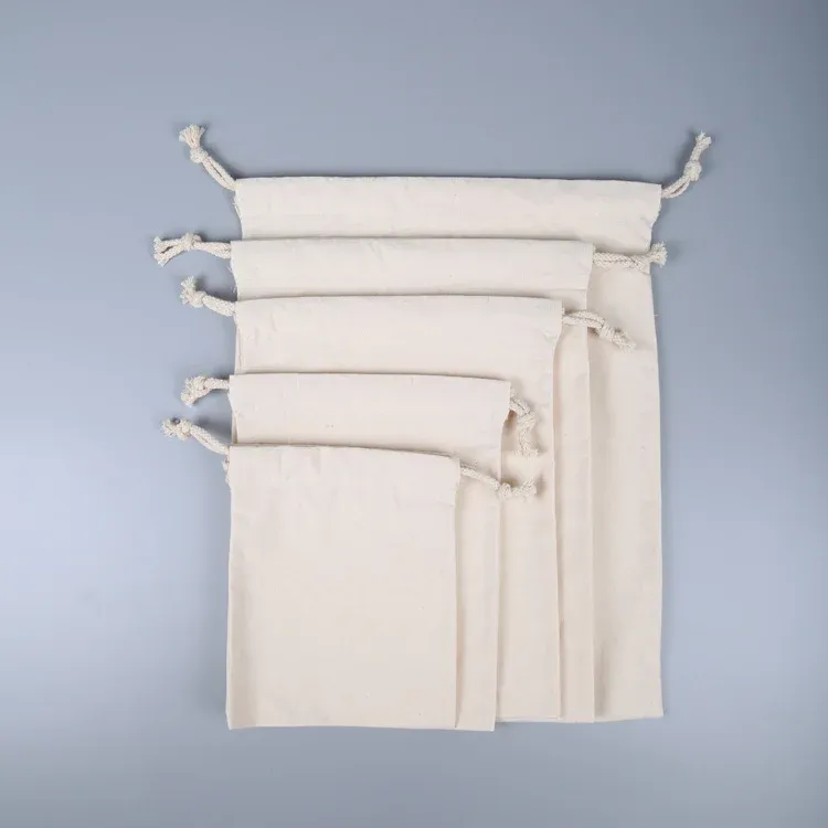 Five natural canvas drawstring pouches in graduated sizes arranged small to large, angled view