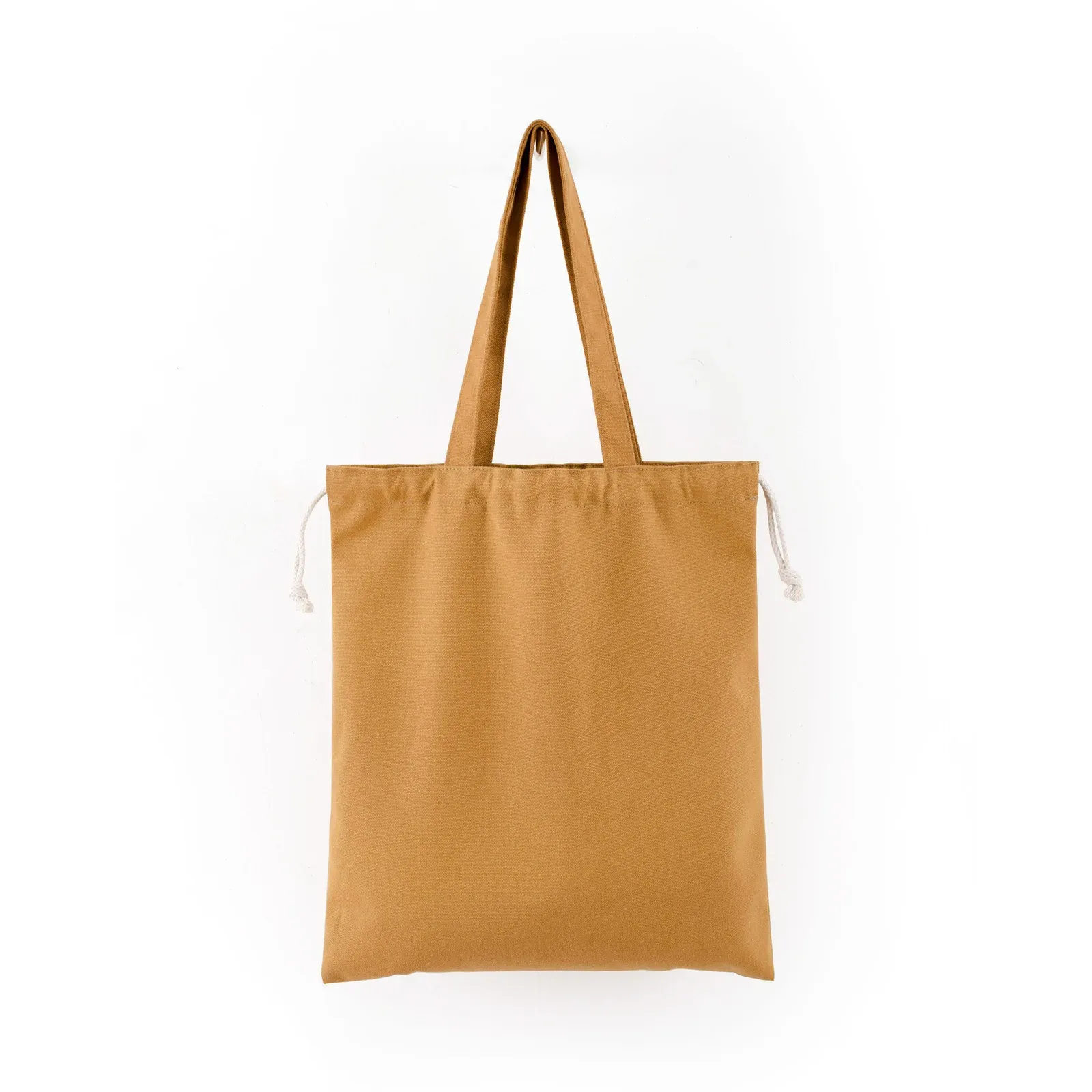 Mustard yellow 12oz canvas drawstring tote with side carry handles and white cotton drawstring closure, front view