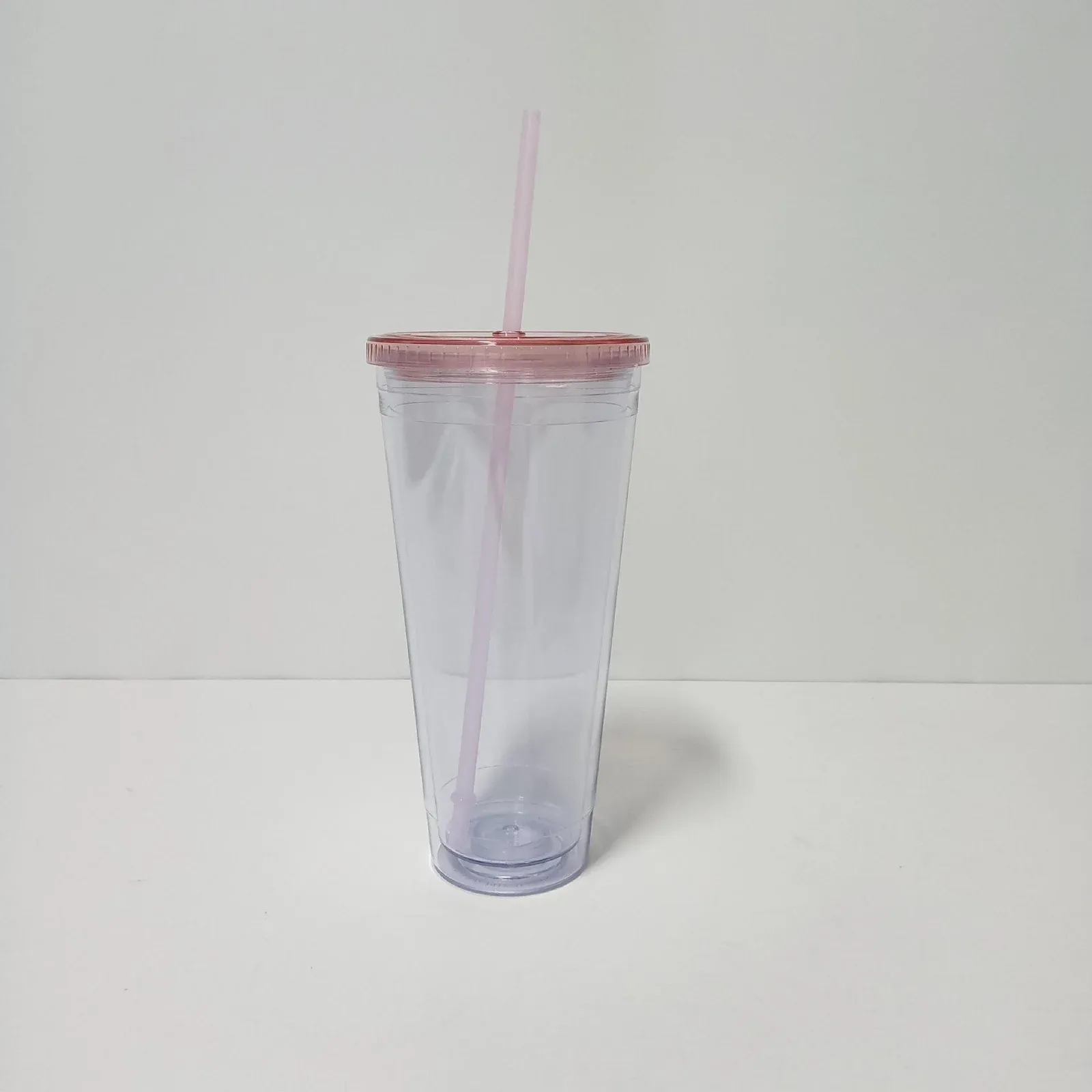 Clear double-wall plastic tumbler with translucent pink lid and pink straw, no handle