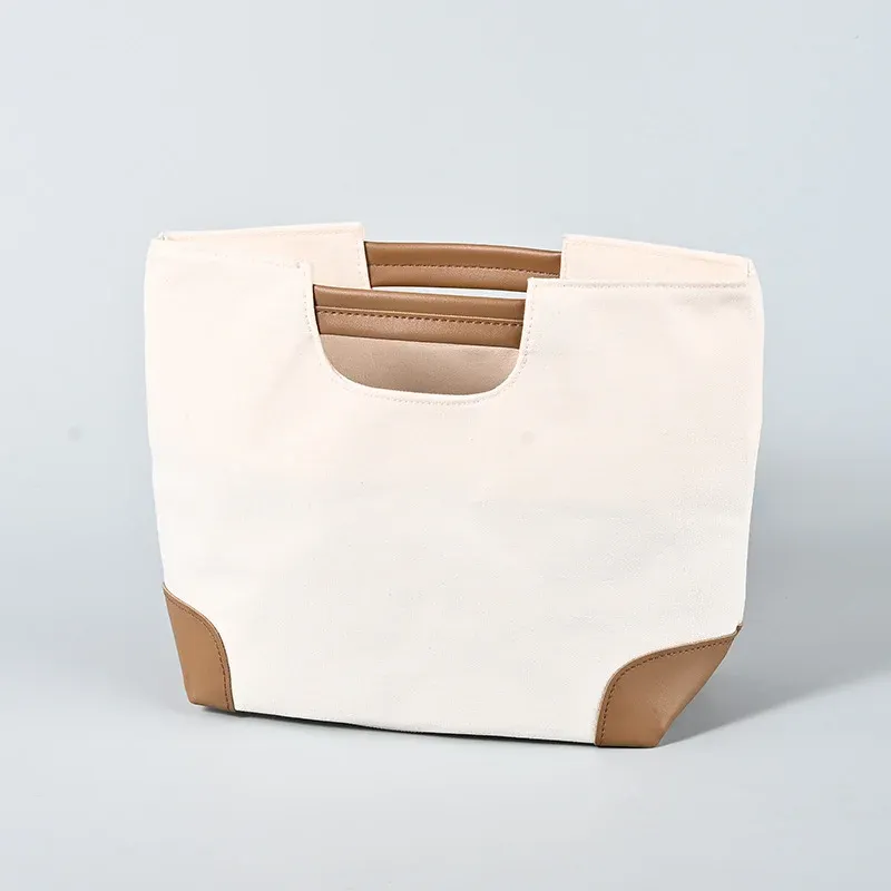 Cream canvas tote with brown trim and padded brown short handle, front view