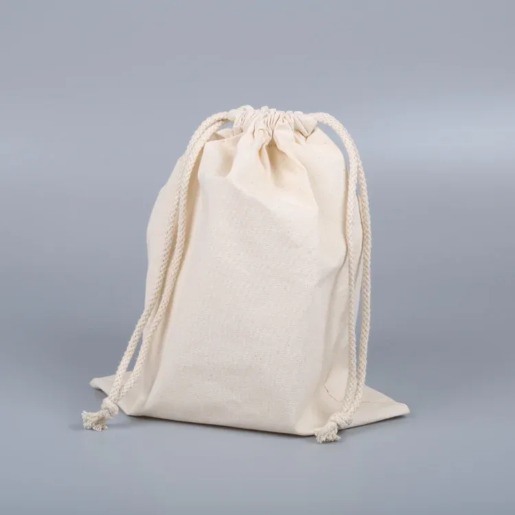 Flat natural canvas drawstring pouch standing upright, cinched closed with long cotton drawcords