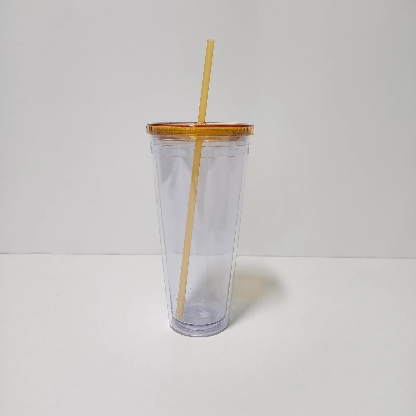 Clear double-wall plastic tumbler with translucent orange lid and orange straw, no handle