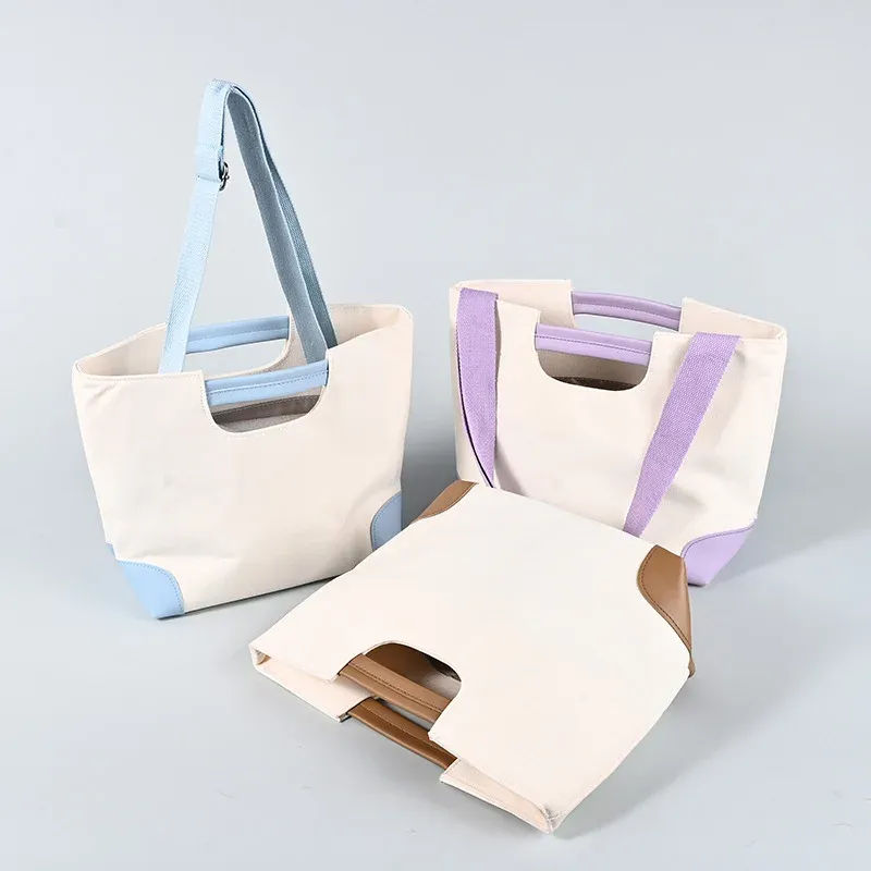 Three cream canvas tote bags with light blue, purple and brown trim, padded short handles and adjustable shoulder straps with metal adjusters