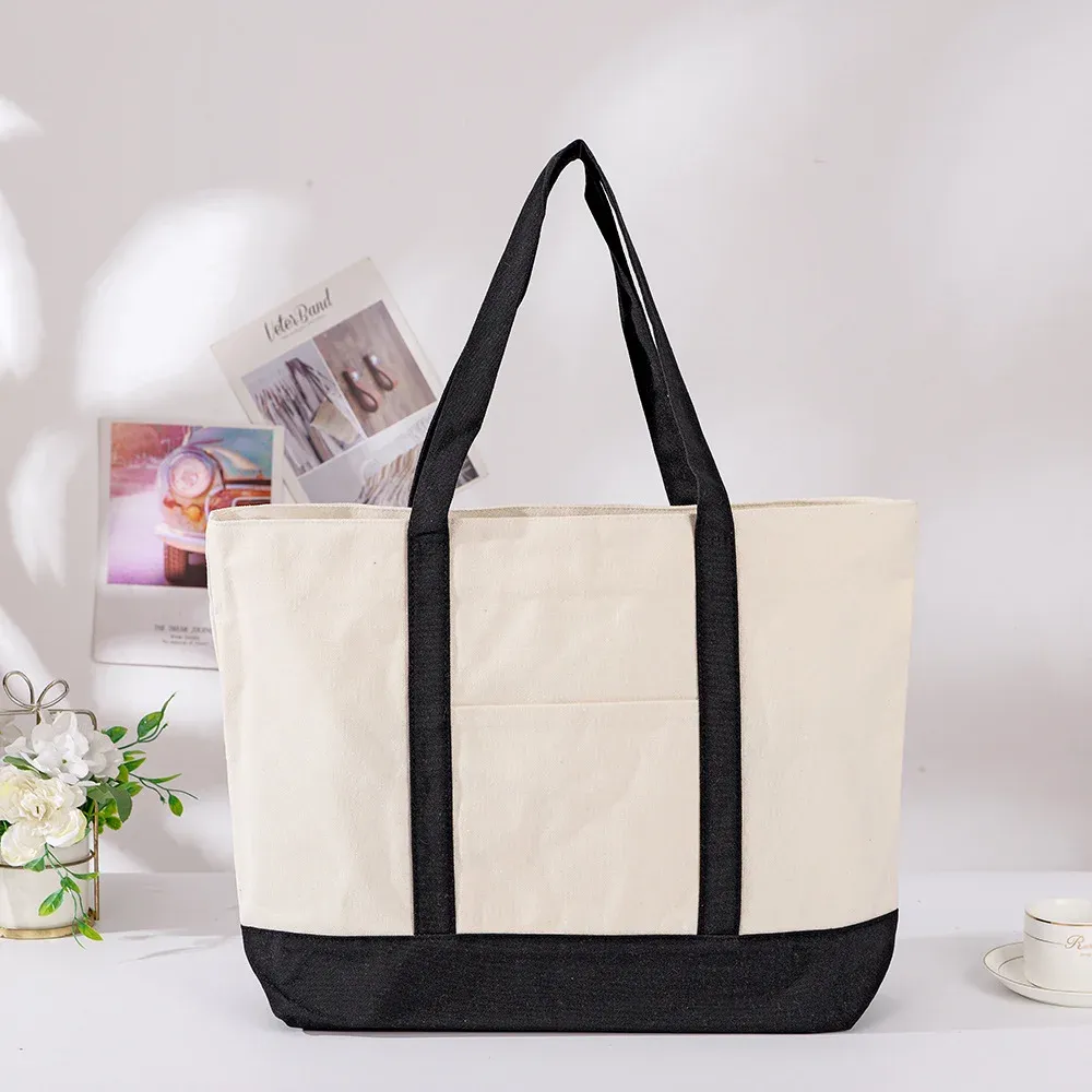 Large cream canvas tote with black webbing handles, black contrast base and a front slip pocket
