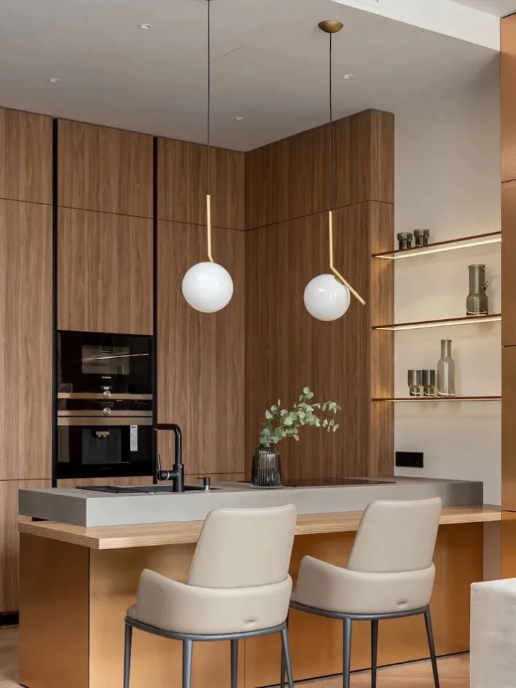 Modern brass and white glass globe pendant lights above a kitchen island, including SPP-2602 with an asymmetrical metal arm.