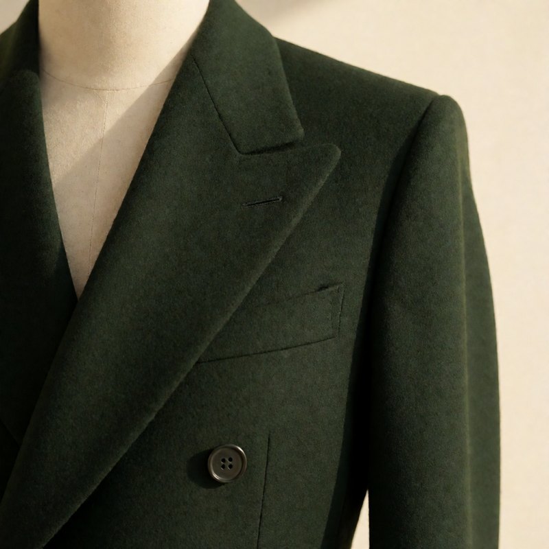 Close-up of the peak lapel and structured shoulder in army green wool