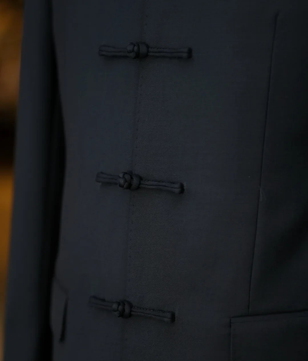 Frog-button closure detail on mandarin collar