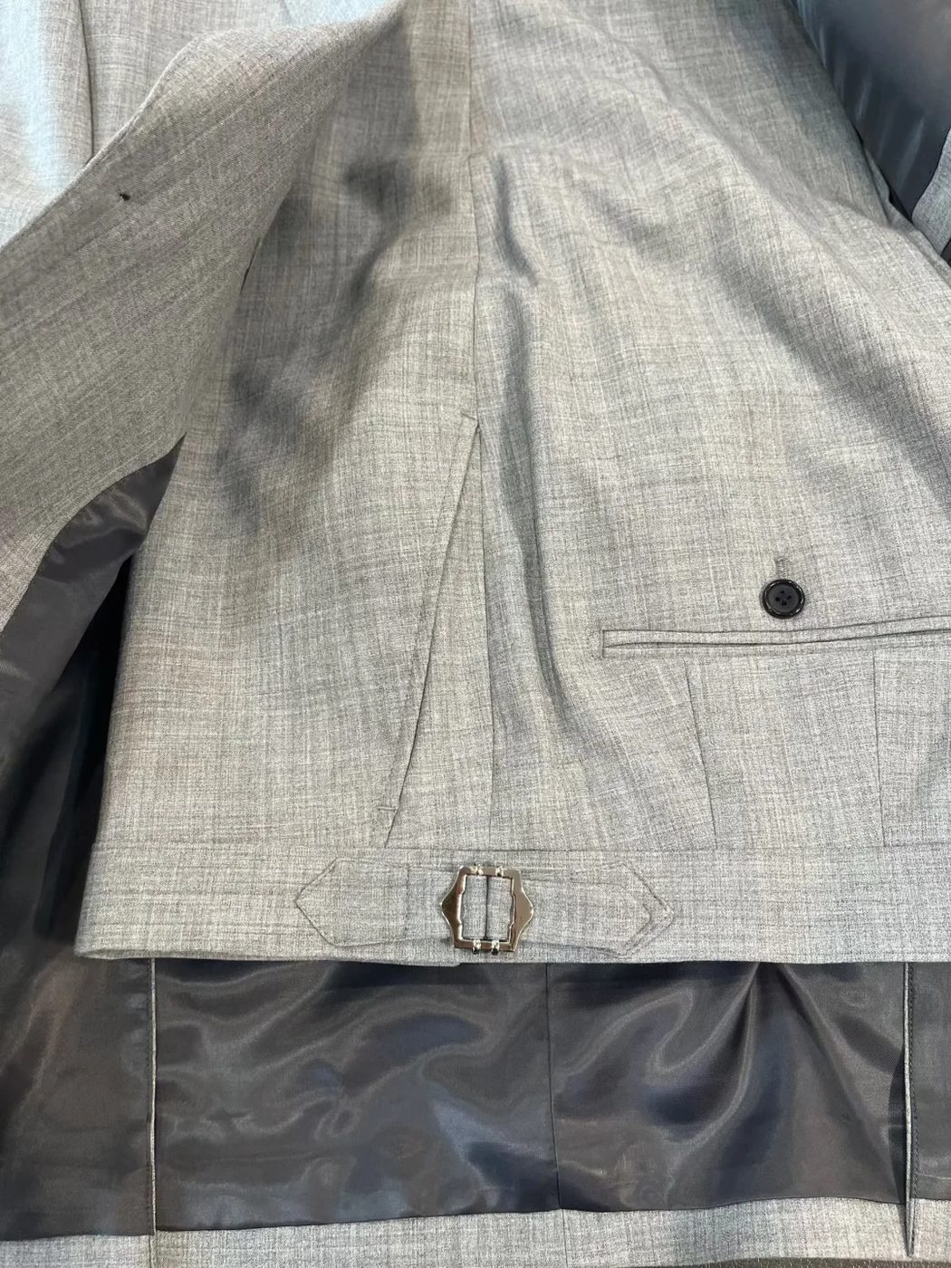 Trousers waistband with side adjusters close-up