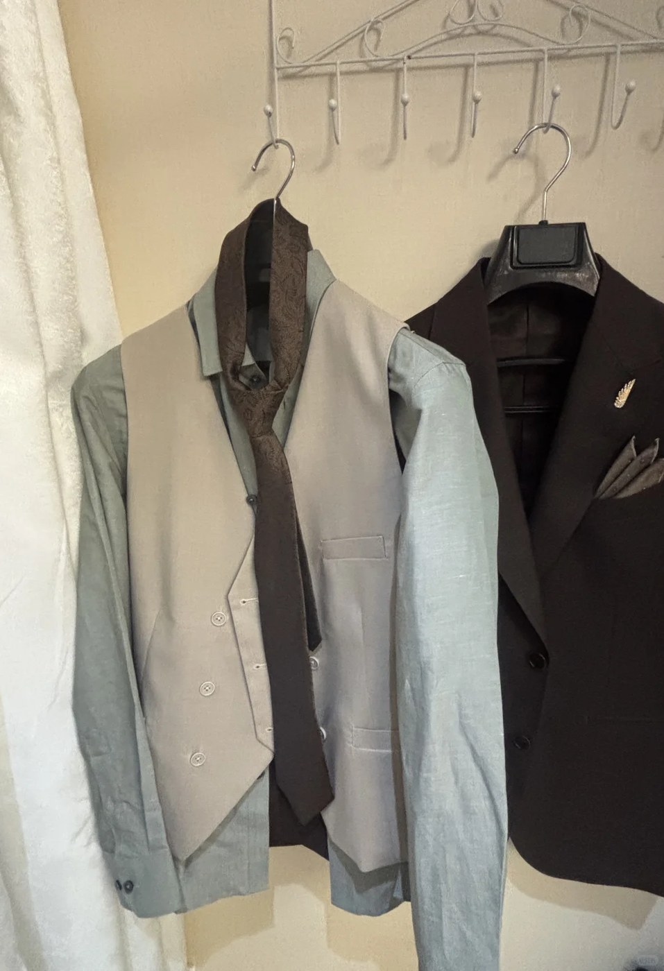 Two waistcoats with shirts on hangers