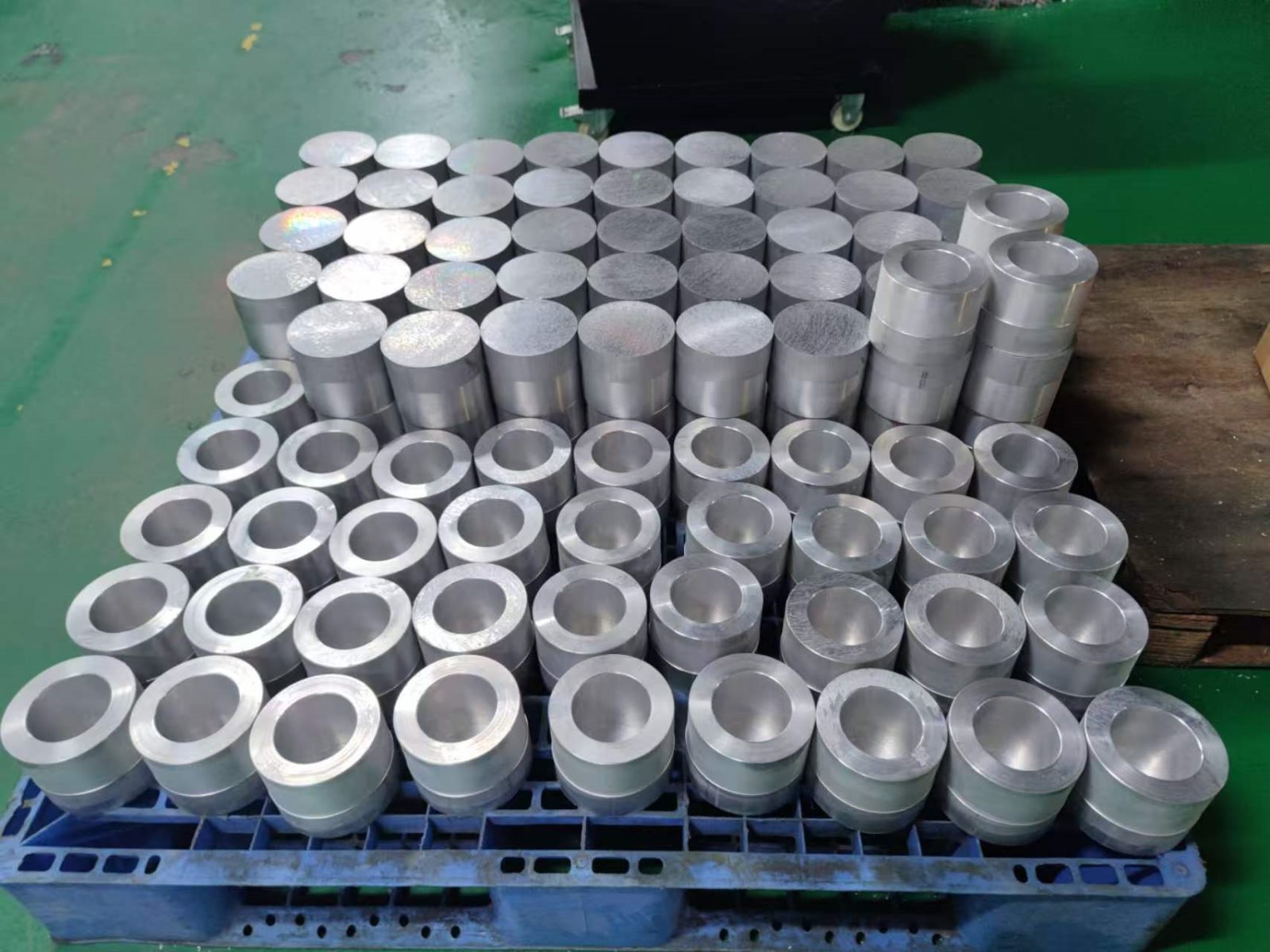 Production batch of CNC machined aluminum turned parts on a pallet in the workshop