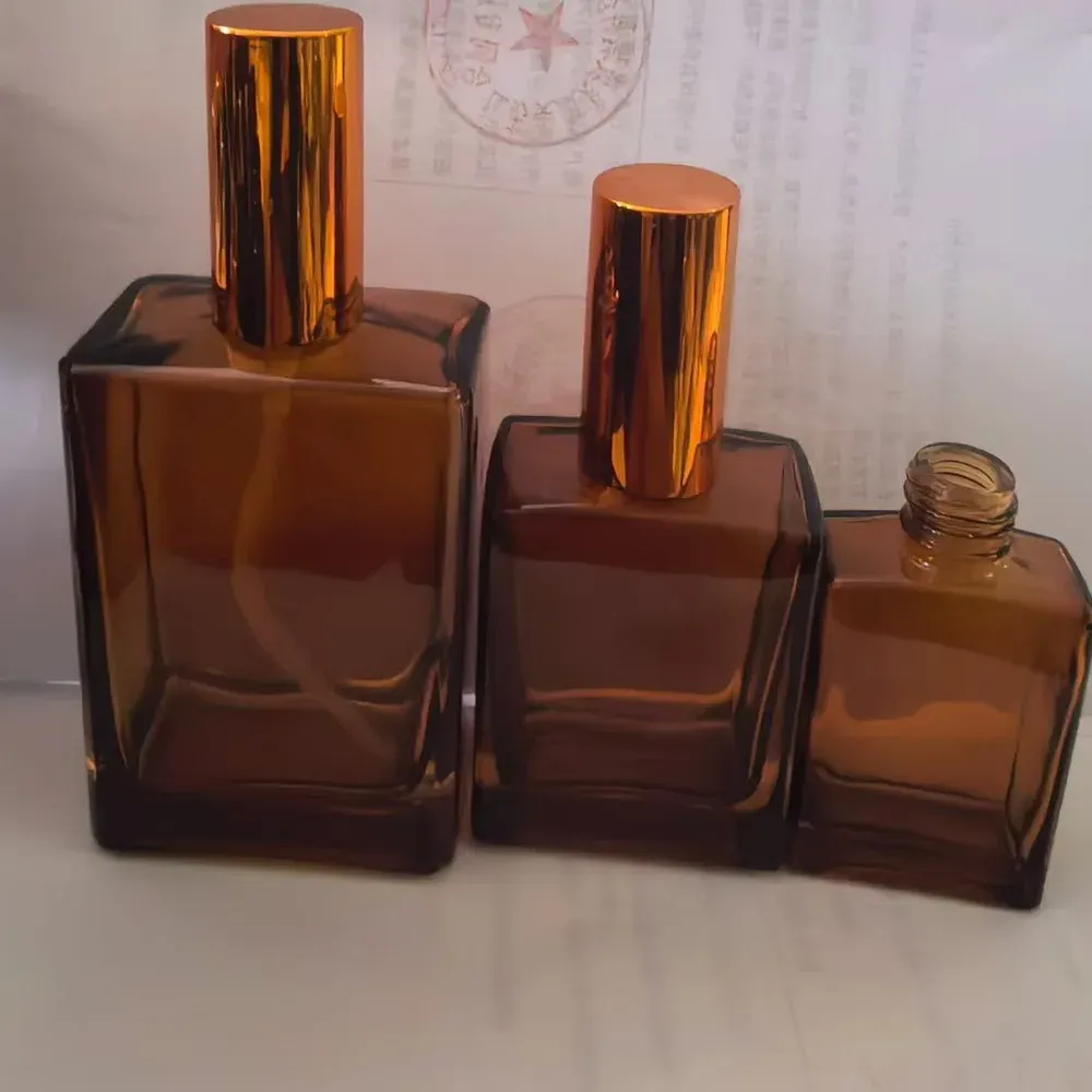 Square amber glass bottles with tall gold caps and an exposed threaded glass neck