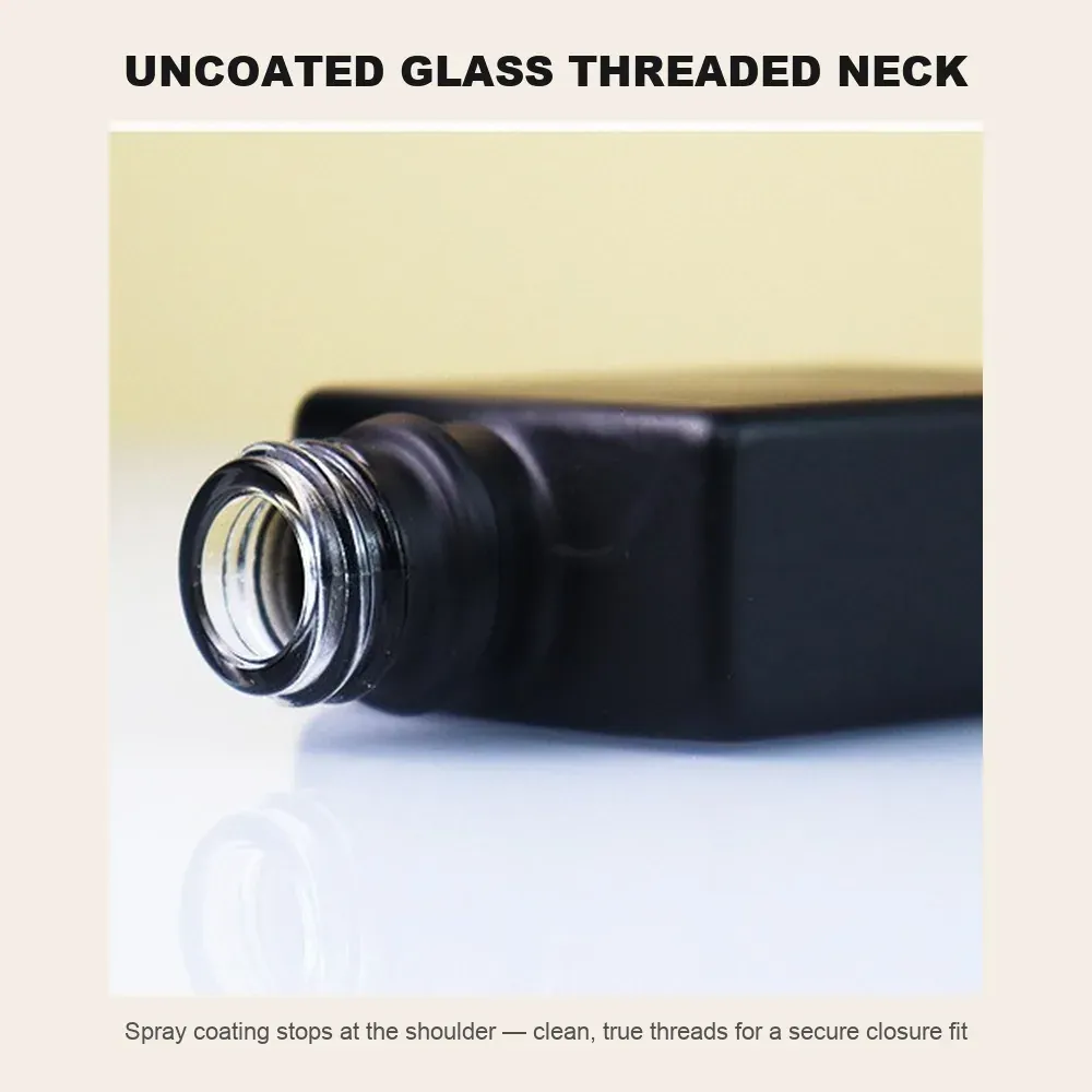 Uncoated glass threaded neck macro of a matte black flat square bottle