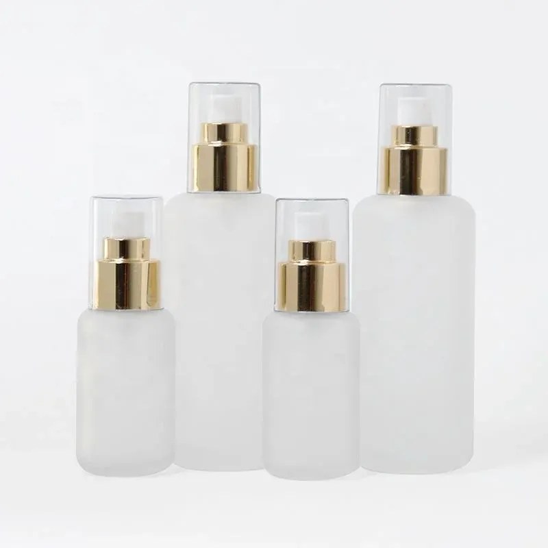 Four frosted glass spray bottles with gold collars and clear caps