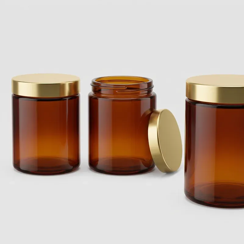 Amber straight-sided glass jars packaging system: closed jar, threaded neck detail with its gold lid standing upright, and a low-angle view of a closed jar