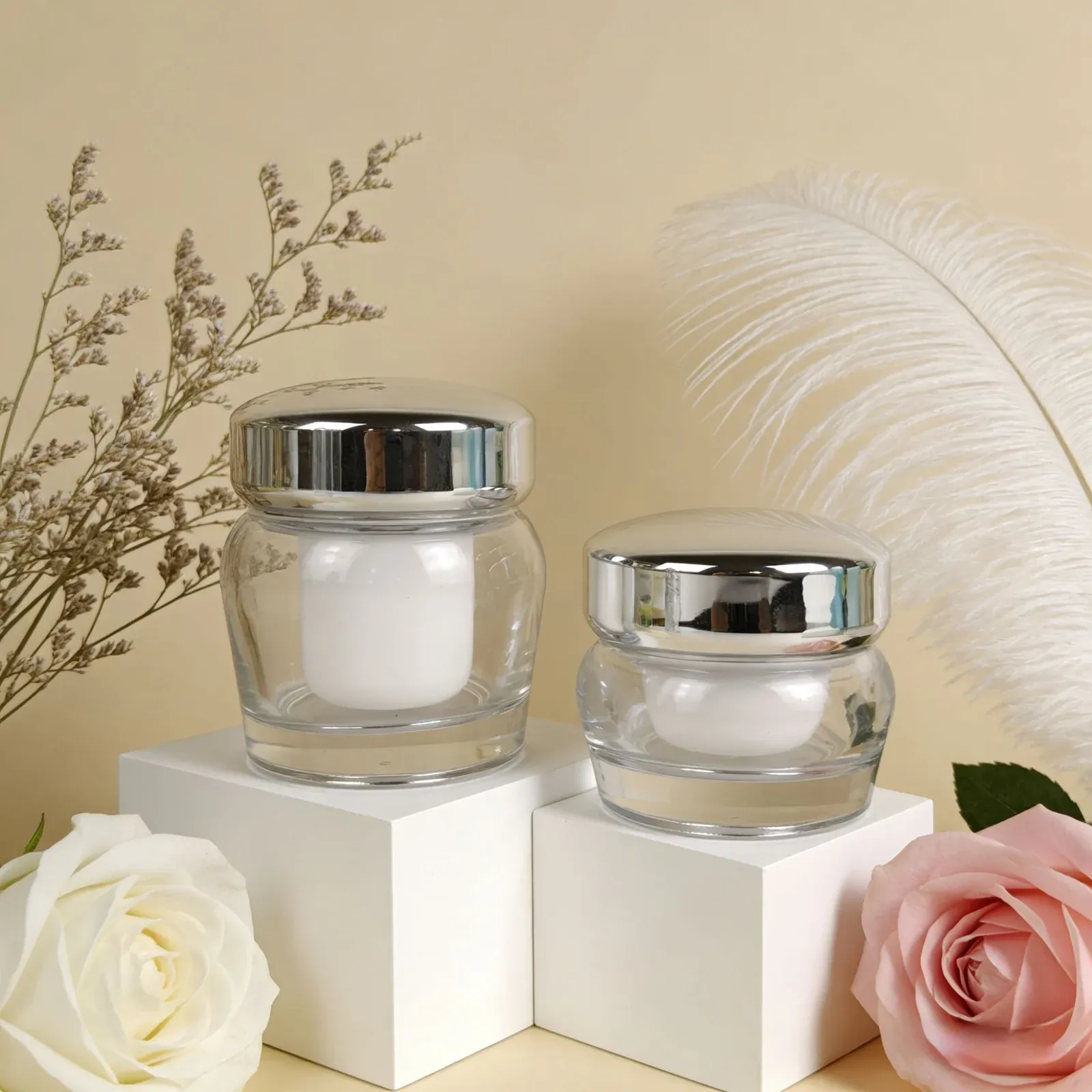 Two clear glass cream jars with shiny silver lids
