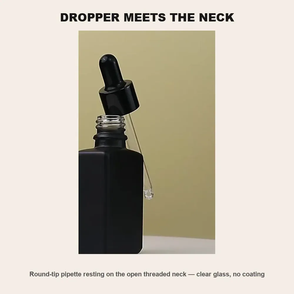 Round-tip glass pipette resting on the open uncoated threaded neck of the matte black flat square bottle