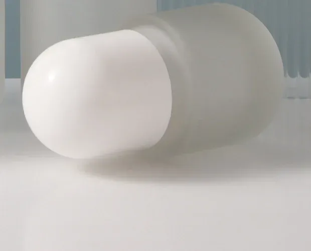 White dome cap resting on a frosted glass bottle, detail view