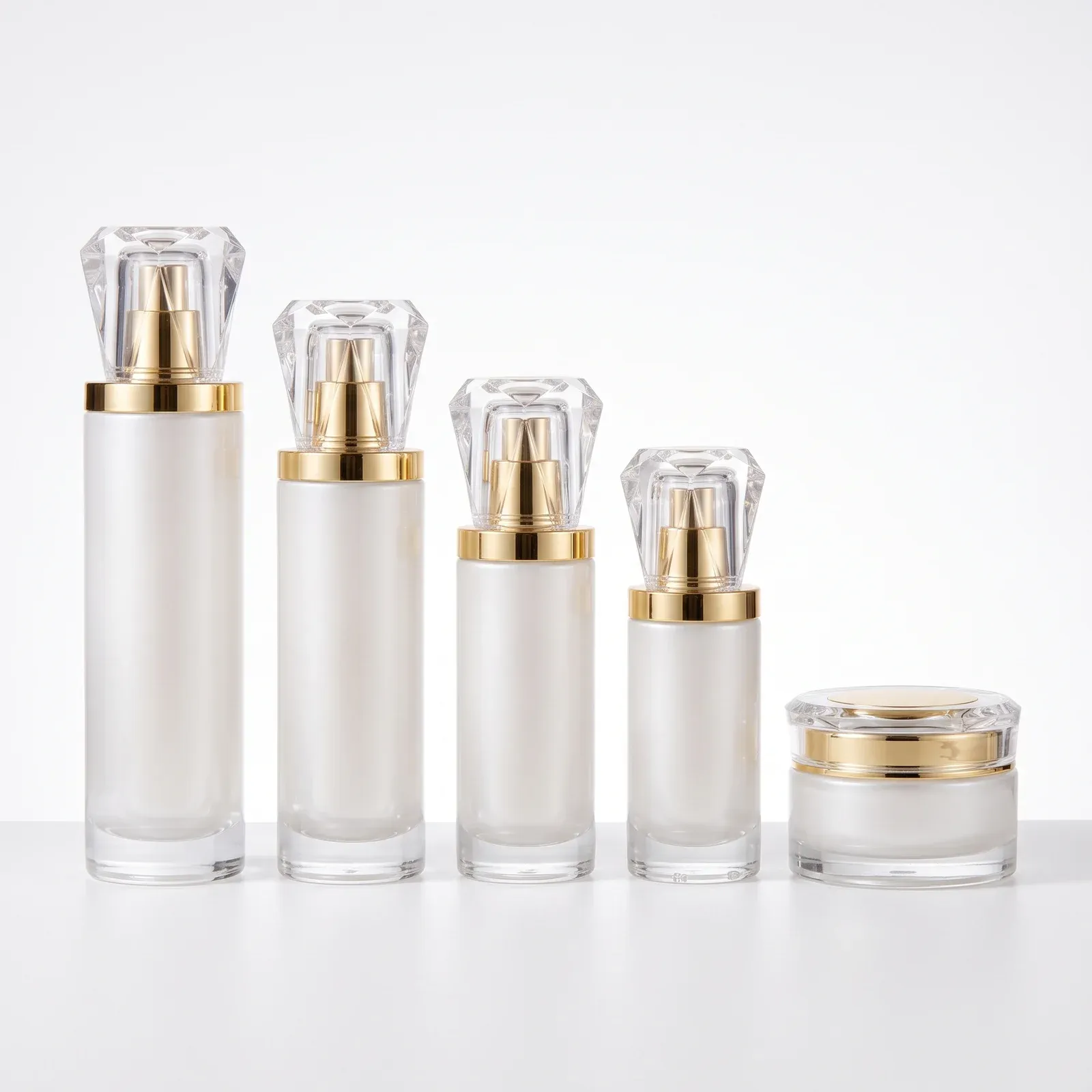 Five-piece pearl-white glass set lineup on white background: four bottles tall to small with crystal-cut caps and one cream jar