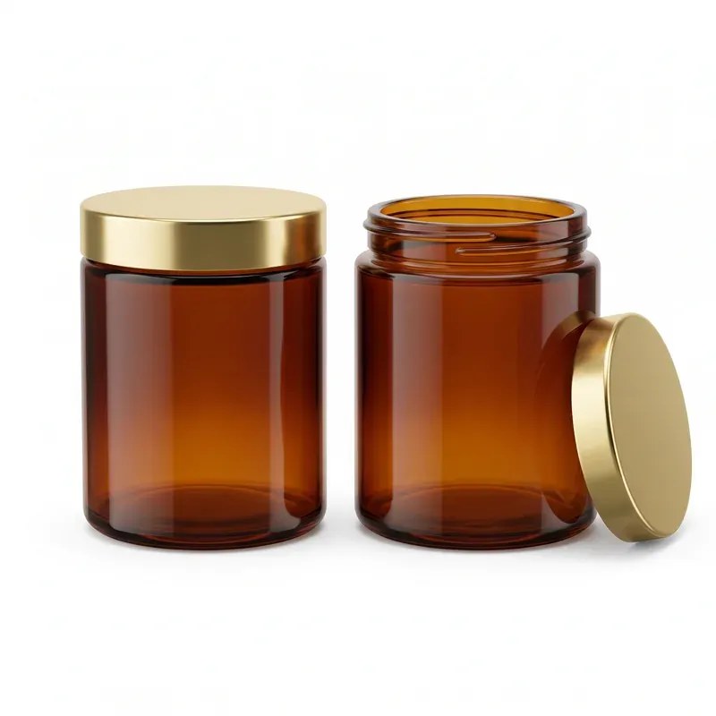 Two amber straight-sided glass jars on white background: one closed with a polished gold screw lid, one open showing the threaded neck with its gold lid leaning beside