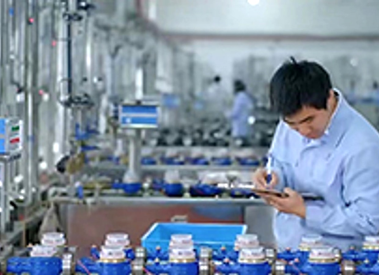 Water meters on the test bench with a technician at the XTHBM plant