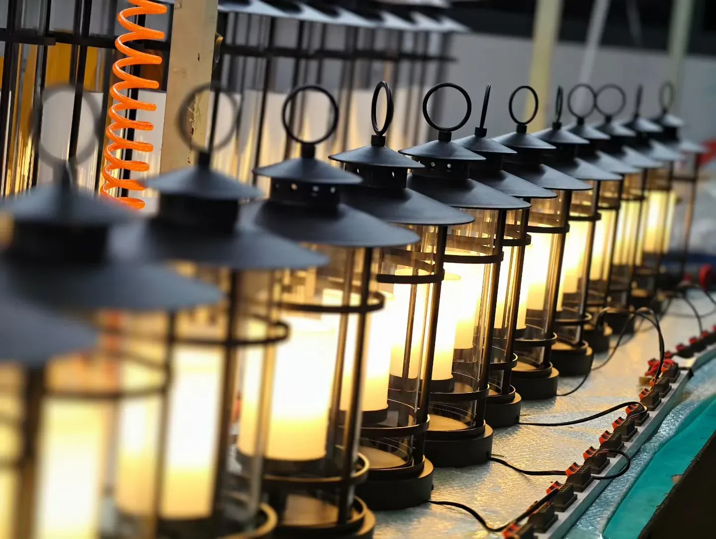 Row of brass garden lanterns lit on the production line - NoorArch Lighting