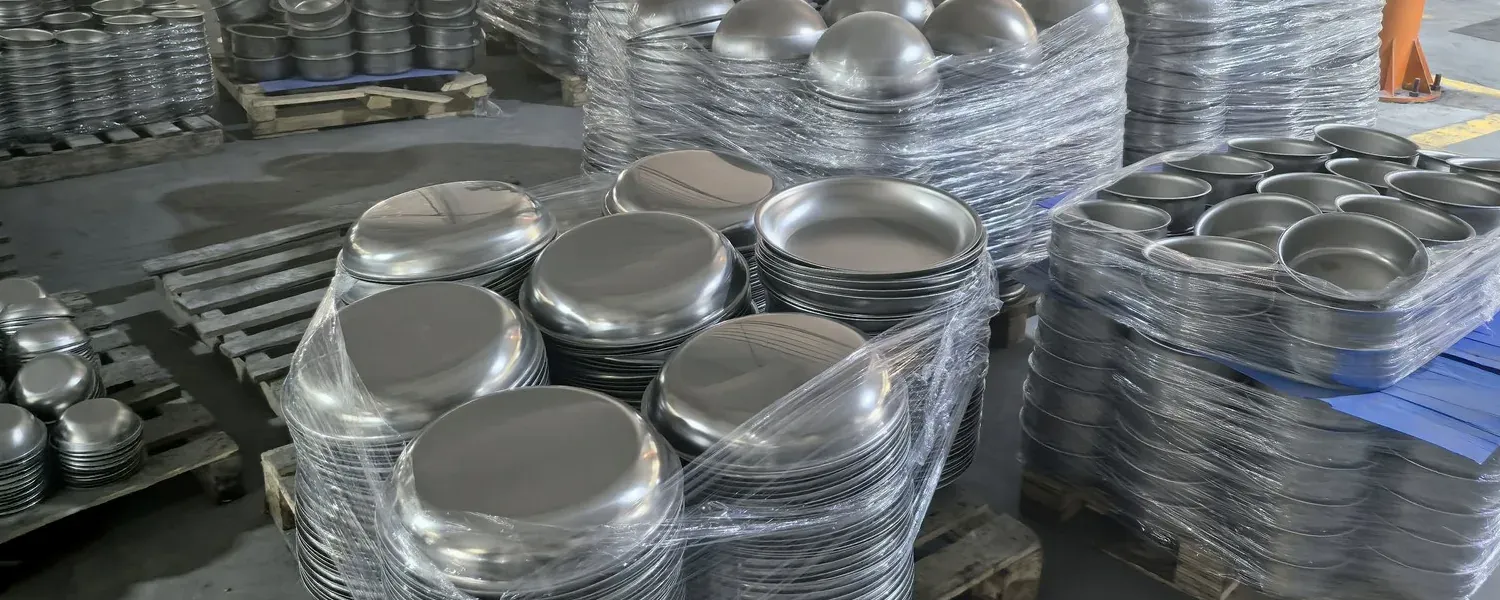 Stacks of formed cookware bodies on pallets in a production area