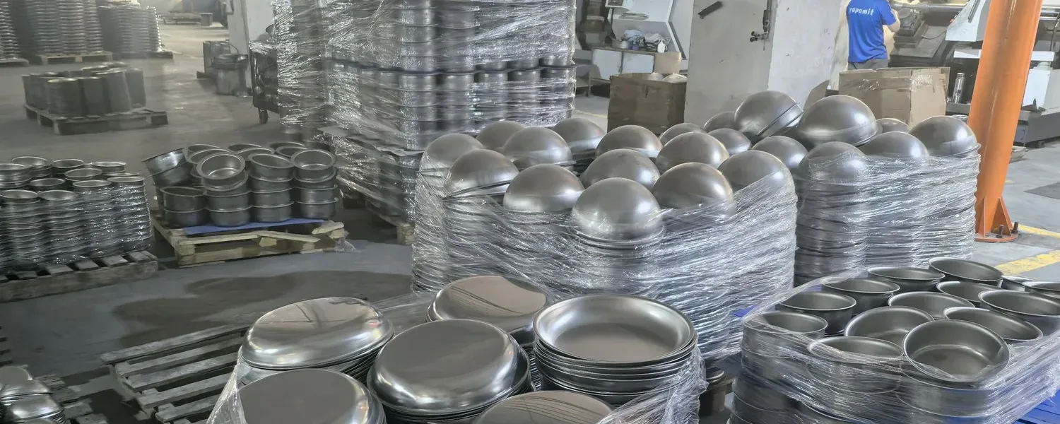 Stacks of formed cookware bodies arranged on pallets in the supplied factory image