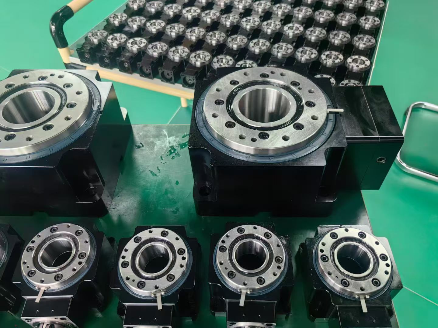 Hollow rotary platforms with through-bores on a production table, with a batch of smaller units behind