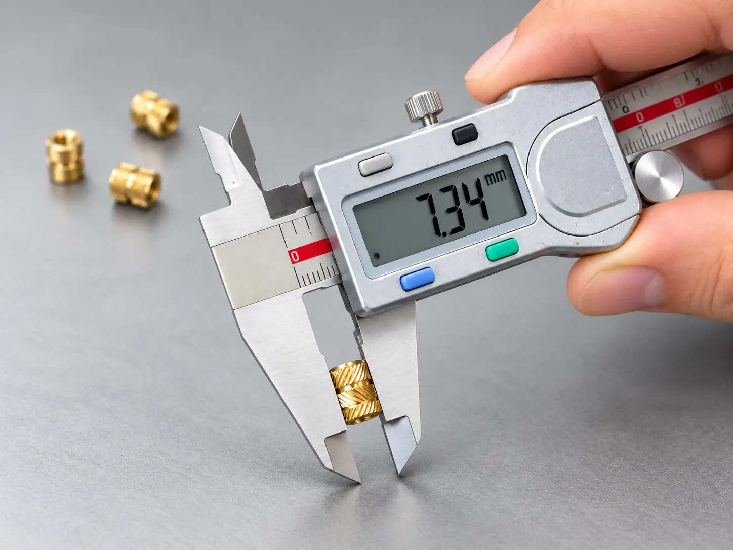 Digital caliper measuring a brass threaded insert to 7.34 mm